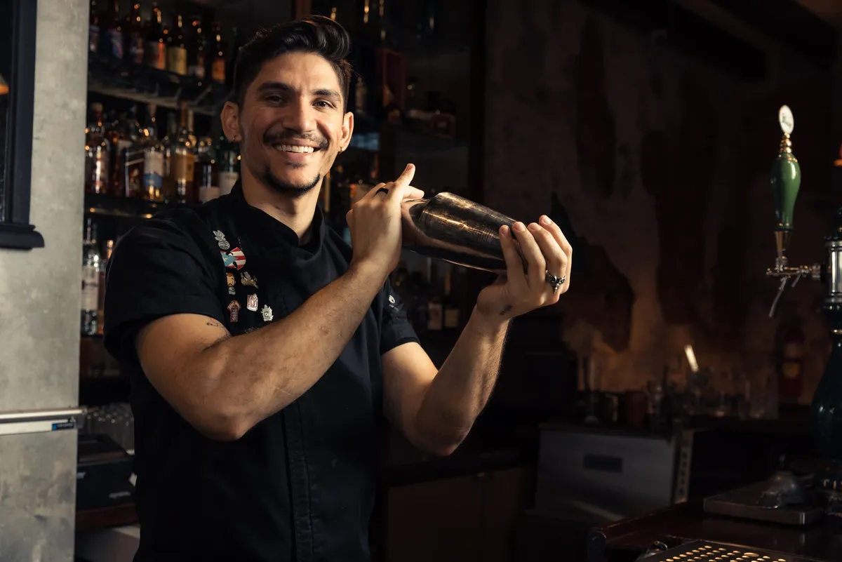 Juan Montes, award-winning mixologist, shaking a cocktail behind the bar