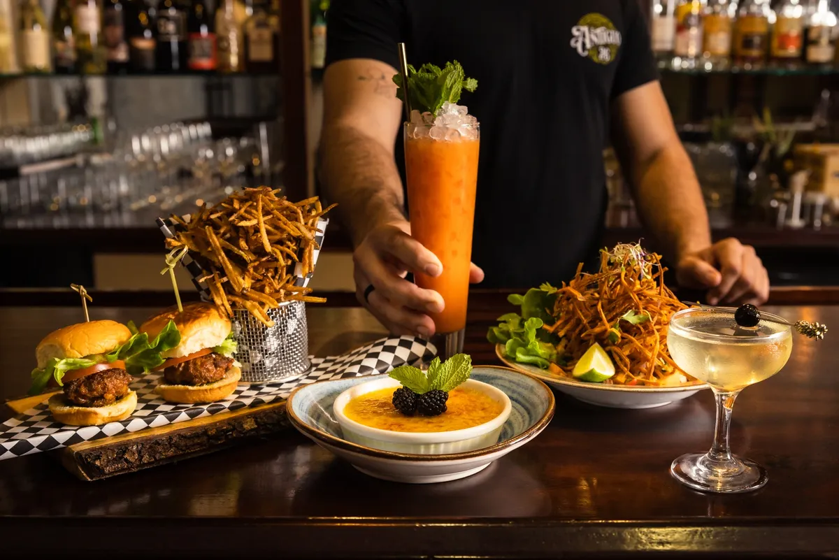 A spread of dishes: sliders, yuca croquettes, bacalaitos and cocktails served at the bar